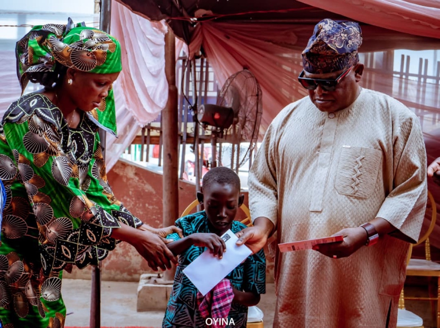 A community elder presenting support to a seated participant